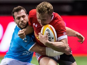 Uruguay's Felipe Berchesi, left, tries to tackle Canada's Ben Lesage during the first half of a Rugby World Cup qualifier match in Vancouver.