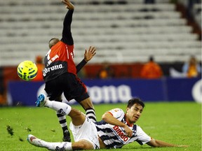 Efrain Juarez of Monterrey (bottom) tackles Marco Da Silva of Atlas during their Mexican Clausura 2015 tournament football match at Jalisco Stadium in Guadalajara on March 14, 2015.