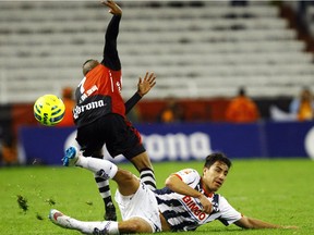 Marco Da Silva of Atlas vies for the ball with Efrain Juarez of Monterrey (on the ground) during their Mexican Clausura 2015 tournament football match at Jalisco stadium in Guadalajara City on March 14, 2015.  Juarez has been picked up by the MLS Vancouver Whitecaps.
