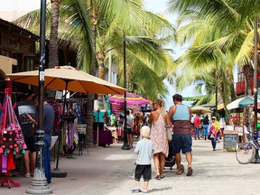 Tourists in the Sayulita street market checkout the eclectic stores featuring Huichol bead art, upcycled glass art and many other unique items.