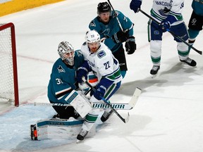 Goalie Martin Jones and Tim Heed defend a crease-crashing Daniel Sedin.