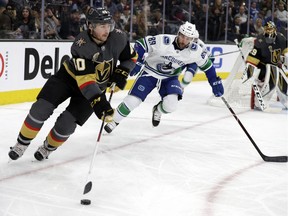 Vegas Golden Knights center Ryan Carpenter (40) skates with the puck as Vancouver Canucks center Sam Gagner (89) defends during the second period of an NHL hockey game Friday, Feb. 23, 2018, in Las Vegas.