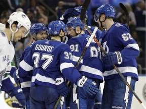 Tampa Bay Lightning center Steven Stamkos (91) celebrates with teammates, including defenseman Andrej Sustr (62) and center Yanni Gourde (37), after scoring against the Vancouver Canucks during the second period of an NHL hockey game Thursday, Feb. 8, 2018, in Tampa, Fla.