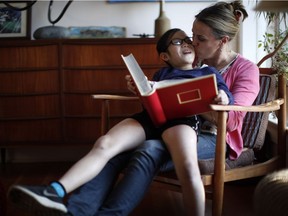 Isabelle Smit, 10, is photographed with her mother Kristen Lundgren as they share a moment while looking through a family photo album in Esquimalt, B.C., on Tuesday, February 20, 2018. Through an online video the mother and daughter are hoping to find Isabelle's birth parents or relatives.