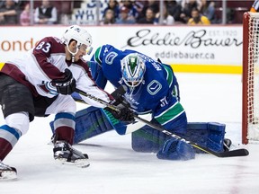Anders Nilsson stops the Avalanche's Matt Nieto during the first period.