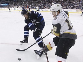 Jets' Patrik Laine (29) and Vegas Golden Knights' Brendan Leipsic (13) fight for possession of the puck during NHL action in Winnipeg on Feb. 1.