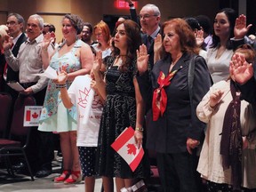 People take the citizenship oath at the Pier 21 immigration centre in Halifax on July 1, 2017.