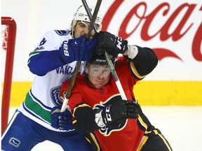 Canucks Christopher Tanev battles with Flames Micheal Ferland in front of the net during NHL action between the Calgary Flames and Vancouver Canucks in Calgary on Tuesday, November 7, 2017. The home provinces of both men are locked in an epic battle for the future of interprovincial trade.