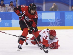 Sarah Nurse, left, and Russian athlete Yekaterina Nikolayeva battle for the puck during the first period of a preliminary-round women's hockey game on Sunday, Feb. 11, 2018.