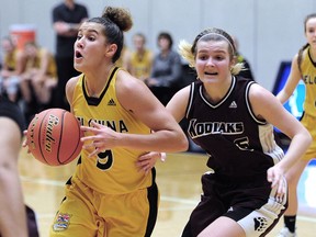 Kelowna's Taya Hanson, left, manoeuvres around Maddy Counsell of Heritage Woods during Wednesday's action in the B.C. high school triple-A provincial girls' basketball championship tournament at the Langley Events Centre.