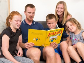 Daniel Sedin of the Vancouver Canucks reads with his family, from left: daughter Ronja, son Erik, wife Marinette and daughter Anna. Research says parents are critical to their children's literacy.