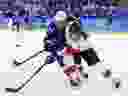 Lauriane Rougeau of Canada, right, and Hilary Knight of the United States battle for the puck during the Olympic gold-medal final earlier this week in Gangneung, South Korea. The U.S. struck gold with a 3-2 victory in a shootout.