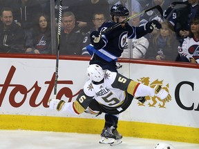 Winnipeg Jets centre Adam Lowry (top) levels Vegas Golden Knights defenceman Deryk Engelland with a shoulder check in Winnipeg on Thurs., Feb. 1, 2018. Kevin King/Winnipeg Sun/Postmedia Network