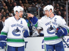 Henrik Sedin #33 converses with Daniel Sedin #22 of the Vancouver Canucks at STAPLES Center on December 01, 2015 in Los Angeles, California.