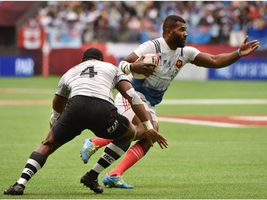 France 7's (blue & white) vs Fiji 7's (white) vie in the HSBC Canada Men's Sevens at BC Place Stadium in Vancouver on March 10, 2018.