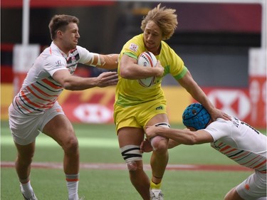Australia's Jesse Parahi (C) is tackled as he runs with the ball during the HSBC Canada Men's Sevens in BC Place Stadium in Vancouver, B.C.Canada, March 11, 2018. Vancouver is the 6th round, played March 10-11, 2018, in the HSBC Men's Sevens 10 round world series.