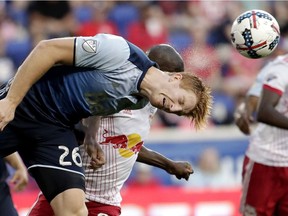 Vancouver Whitecaps defender Tim Parker (26) heads the ball away as New York Red Bulls forward Bradley Wright-Phillips (99) attacks during the second half of an MLS soccer match, Saturday, Oct. 7, 2017, in Harrison, N.J.
