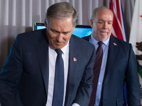 Washington State Gov. Jay Inslee, front, and British Columbia Premier John Horgan leave after a news conference in Vancouver, B.C., on Friday March 16, 2018.