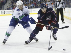 Jake Virtanen of the Vancouver Canucks kept close tabs on Columbus Blue Jackets' Josh Anderson during NHL action in Columbus, Ohio on Friday, Jan. 12, 2018.