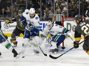 Vancouver Canucks defenseman Michael Del Zotto helps defend the net with help from goaltender Jacob Markstrom.