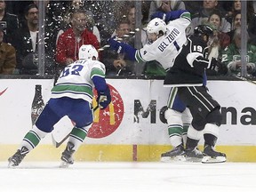 Bo Horvat and Michael Del Zotto collide with  Kings centre Alex Iafallo.