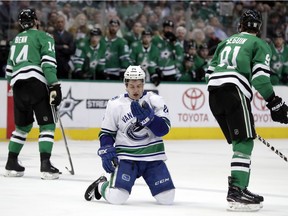 Canucks winger Reid Boucher checks his face after taking a high-stick from the Dallas Stars' Tyler Seguin while Jamie Benn reacts to the call in the second period of an NHL hockey game in Dallas, Sunday, March 25, 2018.