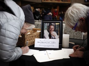People sign a book of condolence for former NDP Premier Dave Barrett is remembered and celebrated during a state memorial service in the Farquhar Auditorium at the University of Victoria in Victoria, B.C., on Saturday, March 3, 2018.