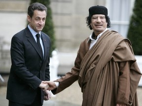 In this Dec. 10 2007 file photo, French President Nicolas Sarkozy, left, greets Libyan leader Col. Moammar Gadhafi upon his arrival at the Elysee Palace, in Paris. Former French President Nicolas Sarkozy was placed in custody on Tuesday March 20, 2018 as part of an investigation that he received millions of euros in illegal financing from the regime of the late Libyan leader.