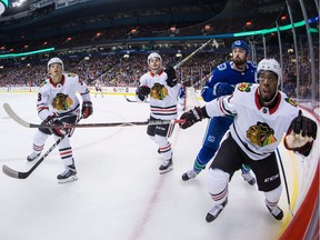Postmedia News hockey writer Jason Botchford suggests the rebuilding Canucks should consider dealing defenceman Erik Gudbranson, surrounded here last month by Chicago Blackhawks Ryan Hartman, Alex DeBrincat and Anthony Duclair, to improve the team's suspect defence.