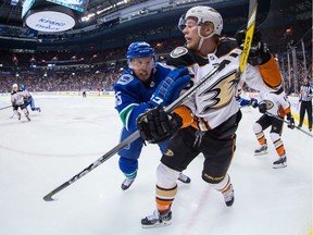 Vancouver Canucks' Alex Biega, left, checks Anaheim Ducks' Ondrej Kase, of the Czech Republic, during the first period of an NHL hockey game in Vancouver, B.C., on Tuesday March 27, 2018.