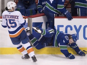 Brock Boeser tumbles into bench gate after attempting to check Cal Clutterbuck.