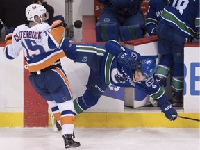 Brock Boeser is helped to the dressing room after colliding with New York Islander Cal Clutterbuck on Monday.