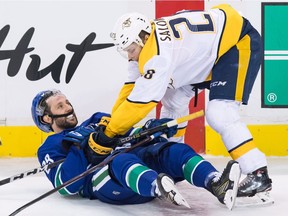 Nashville Predators' Miikka Salomaki, right, of Finland, checks Vancouver Canucks' Sam Gagner, and is given a penalty for interference, during second period NHL hockey action in Vancouver on Friday, March 2, 2018.