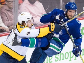 Nashville Predators' Filip Forsberg, left, checks Vancouver Canucks' Alexander Edler, both of Sweden, during Friday's game at Rogers Arena.