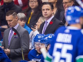 Vancouver Canucks' head coach Travis Green, centre, and assistant coach Newell Brown, left, work the bench during NHL action in Vancouver.