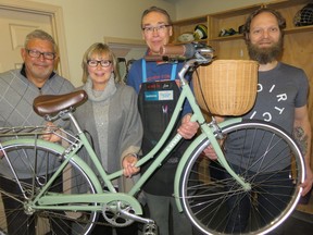 Allan Partridge, left, and Barbara Partridge are grateful to Sports Central general manager Jim Harvey and Jay Smith of Redbike, who played significant roles in the return of their late daughter Martine Partridge's stolen bike.