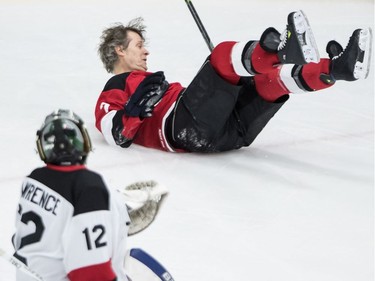 Jim Cuddy falls to the ice after being stopped by Grant Lawrence during a skills competition during the Juno Cup Friday.