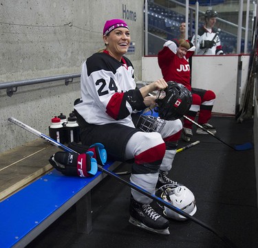 Olympian Natalie Spooner smiles as she puts on her helmet on the bench as the Juno Cup players take to the ice for a practice at the Bill Copeland Sports Centre in Burnaby on March 22, 2018.
