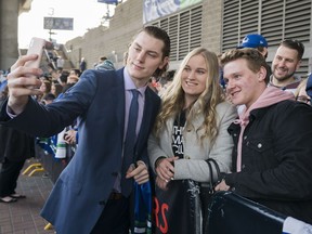 Vancouver Canucks Adam Gaudette (left) take a picture with  Janey Wilson (centre) and Matthew Jenkins prior to their NHL game against the Columbus Blue Jackets in Vancouver, BC, March, 31, 2018.