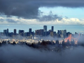 Downtown Vancouver seen through the fog under heavy clouds from Capitol Hill, in Vancouver, Dec, 3, 2017.