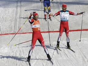 Canada's Brian Mckeever, right, and guide Russell Kennedy celebrate after winning the men's 1.5km sprint classic, visually impaired, cross-country skiing at the 2018 Winter Paralympics in Pyeongchang, South Korea, Wednesday, March 14, 2018.