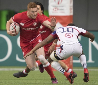 Canada's Connor Braid tries to get past Kevon Williams of the United States during the World Rugby Seven Series at B.C. Place in Vancouver, Saturday, March, 10, 2018.