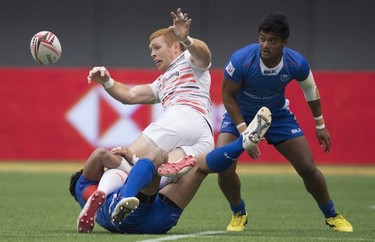 James Rodwell of England gets tackled by members of team Samoa during the World Rugby Seven Series at B.C. Place in Vancouver, Saturday, March, 10, 2018.