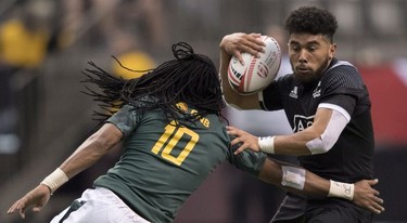 Ngarohi McGrarvey Black of New Zealand tries to keep the ball from Cecil Afrika of South Africa during the World Rugby Seven Series at B.C. Place in Vancouver, Saturday, March 10, 2018.