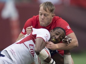 Canada's Harry Jones fights for control of the ball with Perry Baker of the United States during a match at the World Rugby Seven Series at B.C. Place in Vancouver, Saturday, March, 10, 2018.