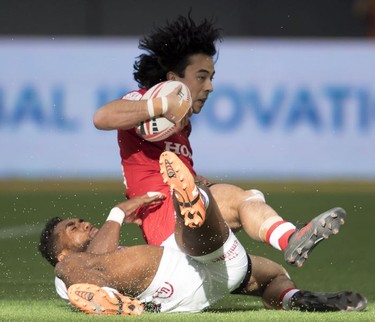 Matai Leuta of the United States throws Nathan Hirayama of Canada to the pitch during a match at the World Rugby Seven Series at B.C. Place in Vancouver, Saturday, March, 10, 2018.