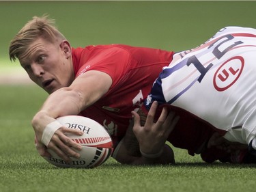 Canada's John Moonlight gets tackled by Martin Iosefo of the United States during the World Rugby Seven Series at B.C. Place in Vancouver, Saturday, March, 10, 2018.