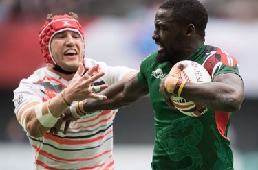 Kenya's Samuel Oliech, right, tries to fight off England's James Rodwell during World Rugby Sevens Series action, in Vancouver, B.C., on Sunday March 11, 2018.