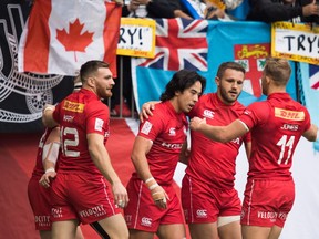 Canada's Nathan Hirayama, centre, celebrates with his teammates after scoring a try against France during World Rugby Sevens Series action in Vancouver on March 11, 2018.