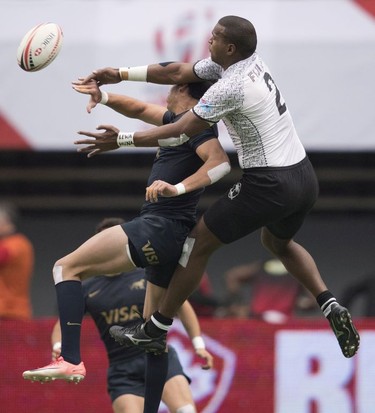 Josua Vakurunabili of Fiji, right, fights for control of the ball with Marcos Moroni of Argentina during the World Rugby Seven Series at B.C. Place in Vancouver, Sunday, March, 11, 2018.